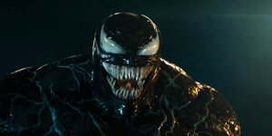 A menacing black figure with a large mouth full of sharp teeth, white eyes, and a muscular build is depicted against a dark background.