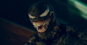 A menacing dark creature with sharp teeth and large white eyes stares menacingly.