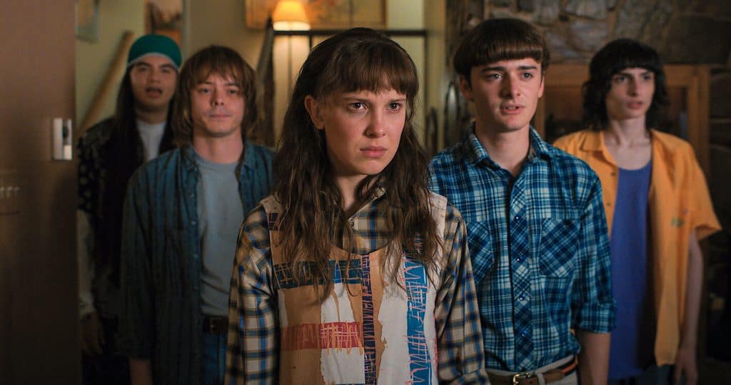 A group of young people standing in a hallway.