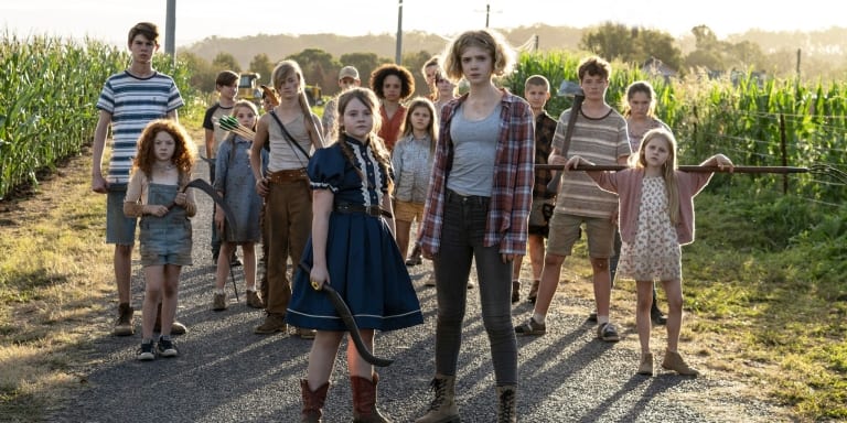 ‘Children Of The Corn’ (2023) 4K UHD Blu-Ray SteelBook Review – The Youth Will Be Our End A group of children with serious expressions standing on a rural road, some holding tools and makeshift weapons.