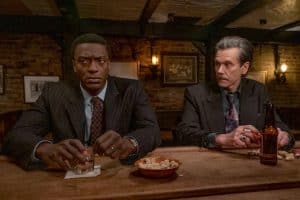Two men in suits sitting at a bar.