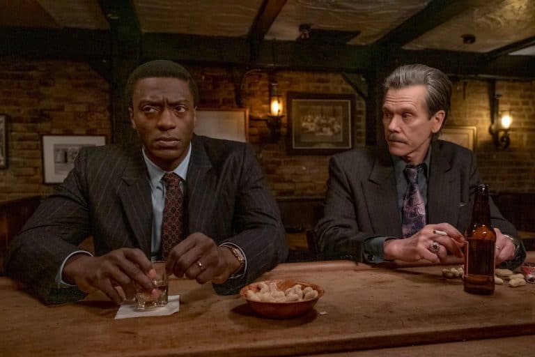 Two men in suits sitting at a bar.