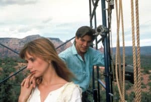 A man and a woman standing on a rope in the mountains.
