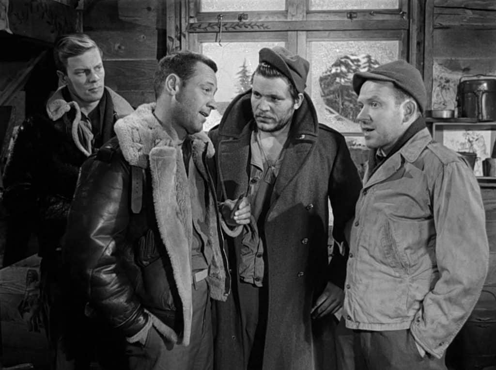 A group of men talking in a cabin.