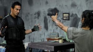 A man points a gun at Joe Taslim in The Raid: Redemption