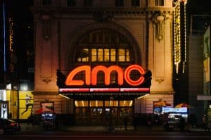 The amc theater in new york city is lit up at night.