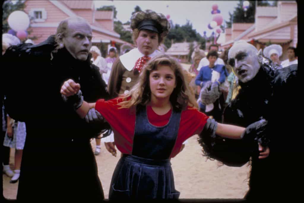 A girl dressed as a witch is standing next to a group of people.