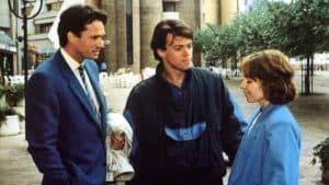 Two men and a woman in blue suits standing next to each other.