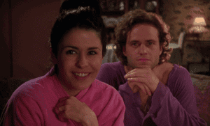 A man and woman in purple robes sitting on a couch.