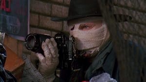 A man in a hat holding a camera.