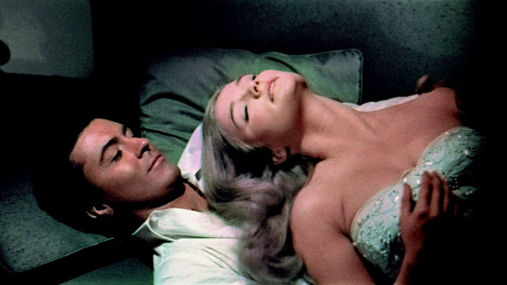 A man and a woman laying on a bed.