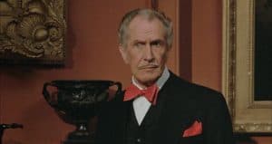 An older man in a tuxedo and red bow tie.