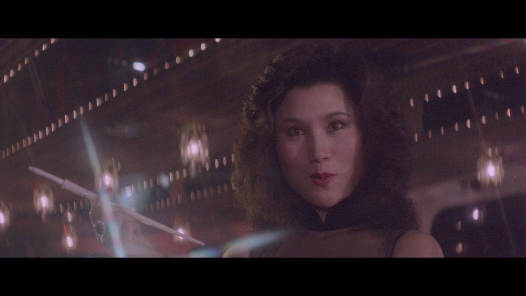 A woman in a black dress holding a wand.
