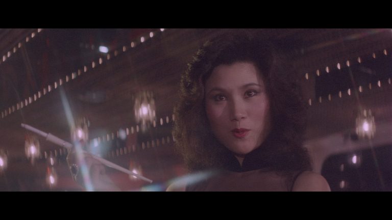 ‘Kill Butterfly Kill’ Blu-Ray Review – Revenge With A Healthy Dose Of Exploitation A woman in a black dress holding a wand.