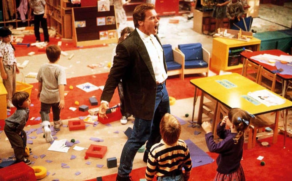 A man in a suit standing in front of a group of children.