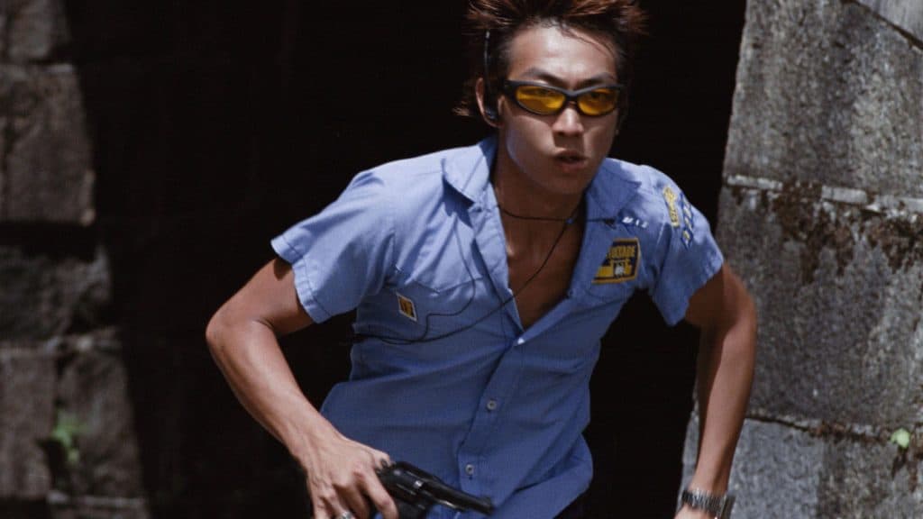 A man in a blue shirt running with a gun.