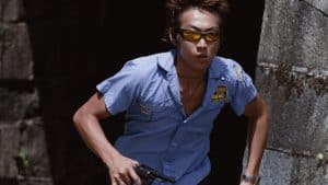 ‘Made In Hong Kong’ Blu-Ray Review – A Gritty Exhale Of Youthful Discontent A man in a blue shirt running with a gun.