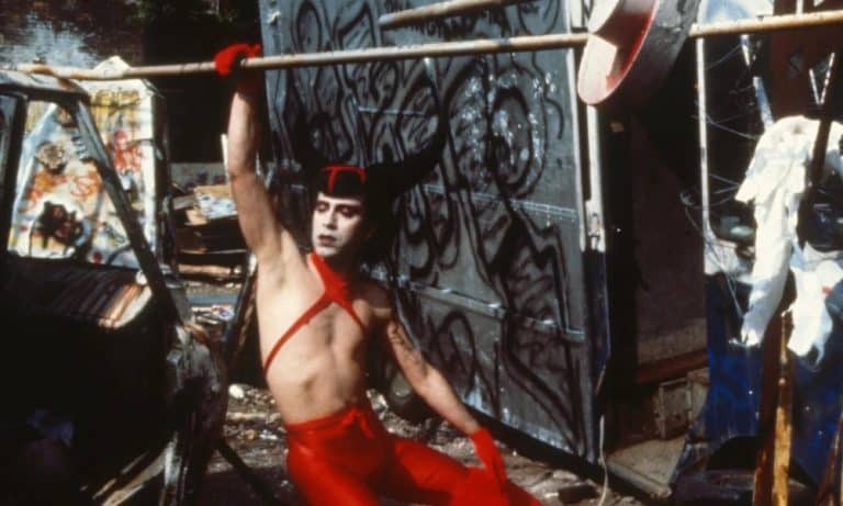 A man in a red outfit holding a bat.