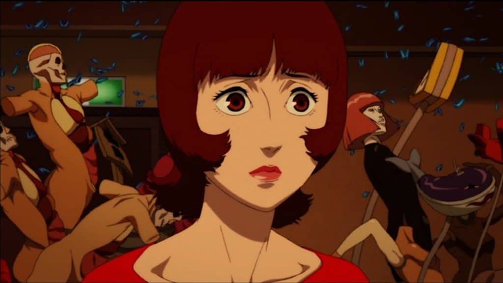 A woman with red hair is standing in front of a group of people.