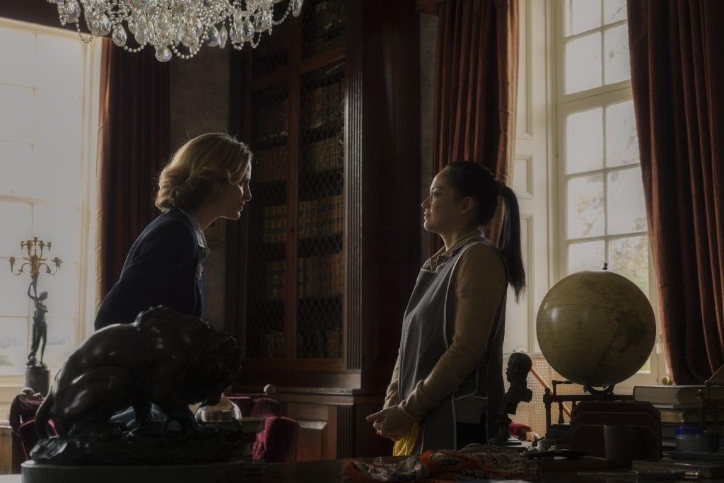 Two women standing in a room with a globe.