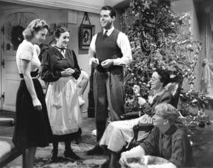 A group of people standing around a christmas tree.