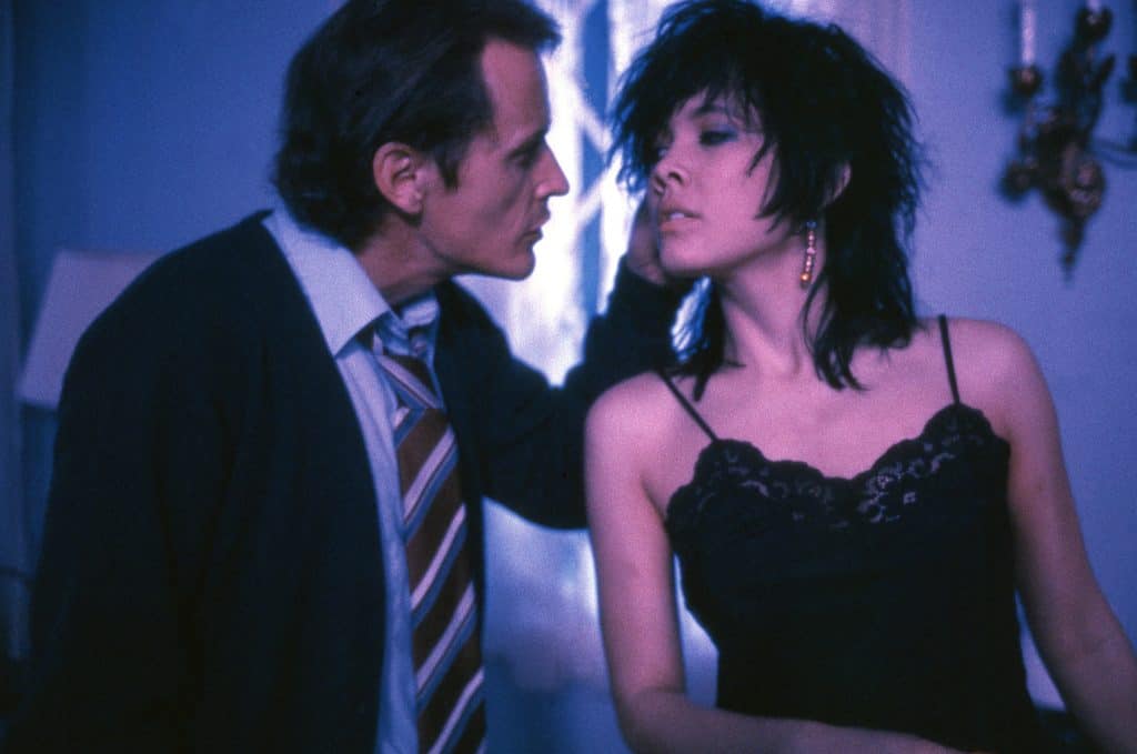 A man and woman standing next to each other in a room.