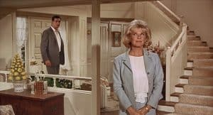 A man and woman standing in front of a staircase.