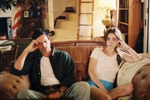 ‘The Sweet East’ Blu-Ray Review – A Twisted Tumbling Down The Rabbit Hole Of America A man and woman sitting on a couch in a living room.