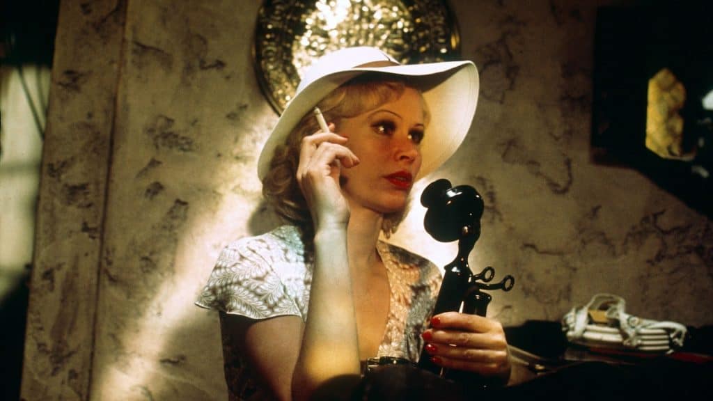 A woman in a white hat talking on the phone.
