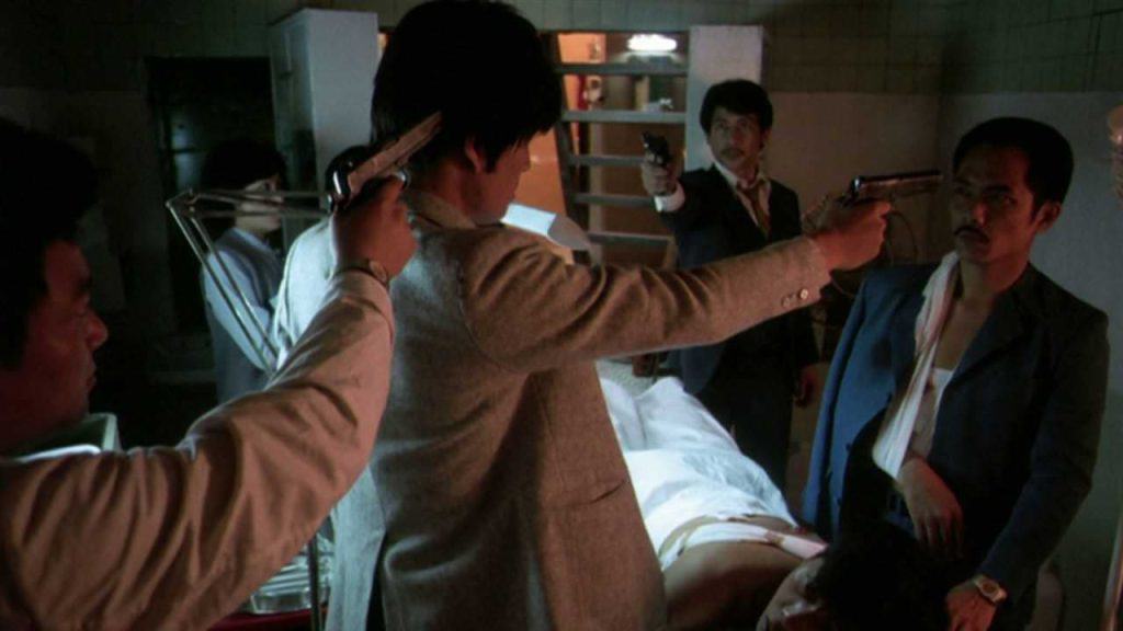 A group of men pointing guns at each other in a hospital.