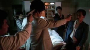 A group of men pointing guns at each other in a hospital.
