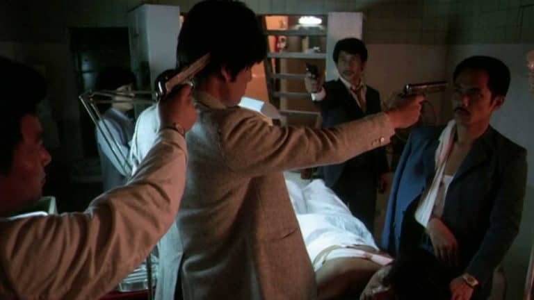 A group of men pointing guns at each other in a hospital.