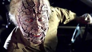 A man dressed as a zombie in a car.