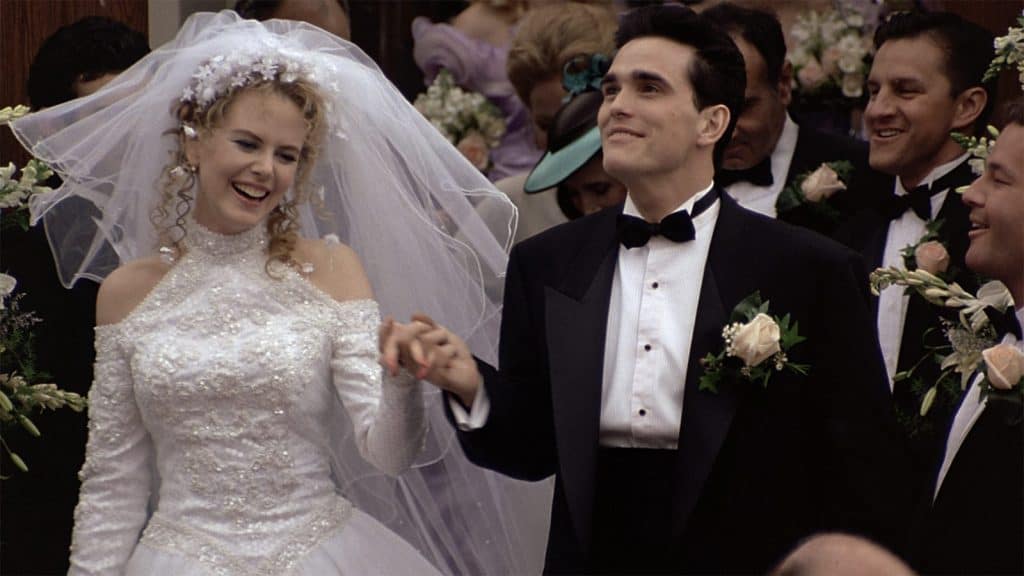 A bride and groom in a wedding gown and tuxedo.
