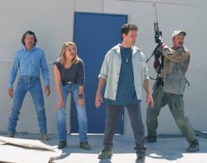 ‘Tremors 2: Aftershocks’ Arrow Video 4K UHD Blu-Ray Review – Deadly Creatures Slither Back For Fun Sequel A group of people standing in front of a building with a gun.