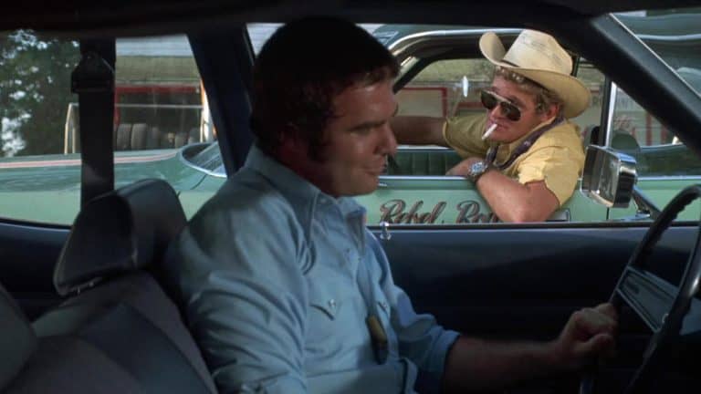 A man in a cowboy hat is driving a car.