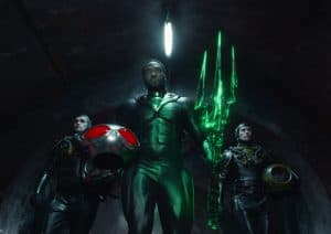 A group of men in green suits standing in a tunnel.