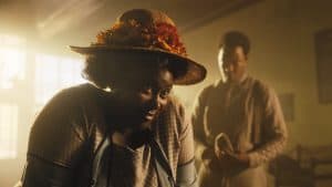 A woman in a straw hat is standing next to a man.