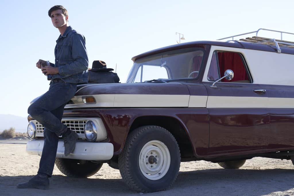 A man leaning on a truck.