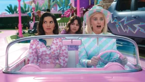 Three women are driving a pink car in a pink park.