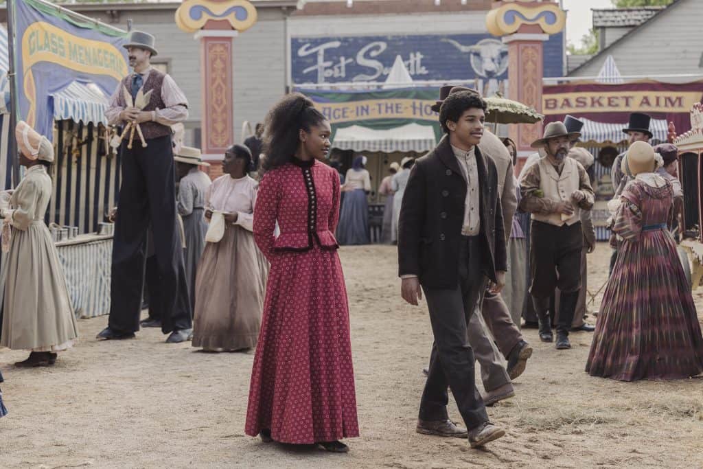 A man and woman are standing in front of a carnival.