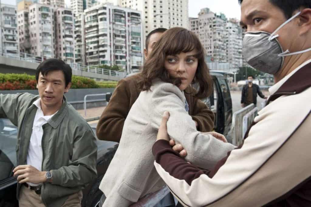 A group of people in a car with a woman wearing a face mask.