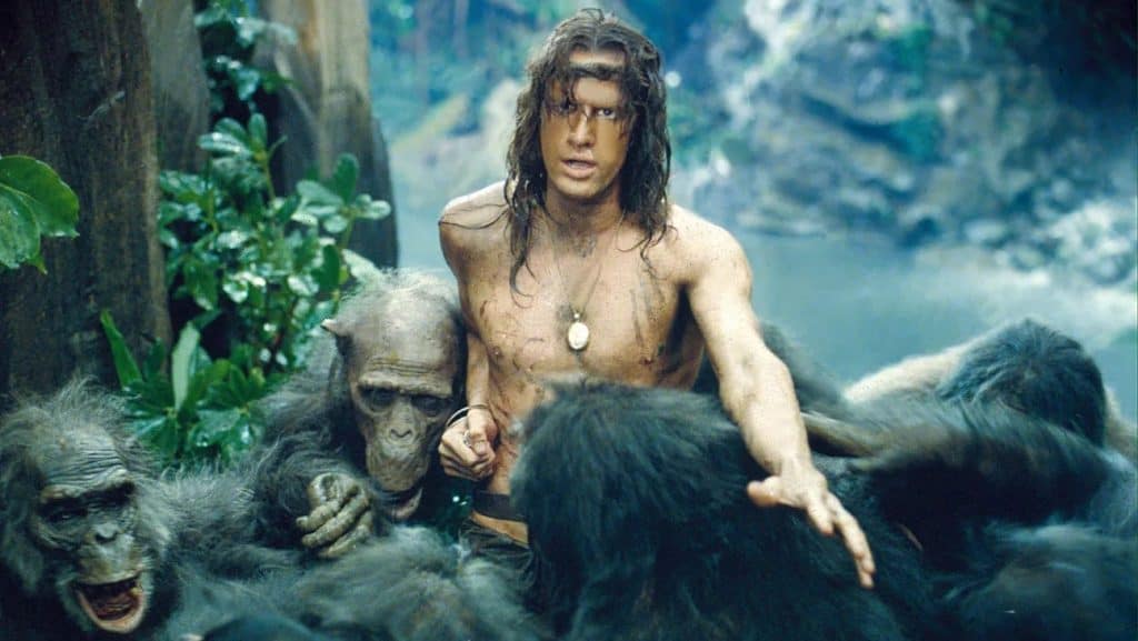 A man is surrounded by a group of apes.