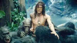 A man is surrounded by a group of apes.