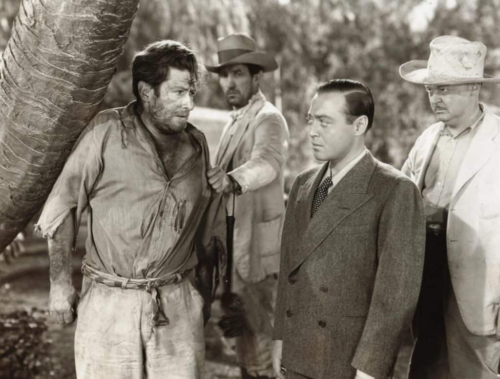 A group of men standing next to a palm tree.