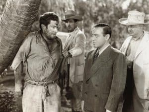 A group of men standing next to a palm tree.