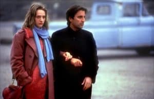 A man and woman standing outside.