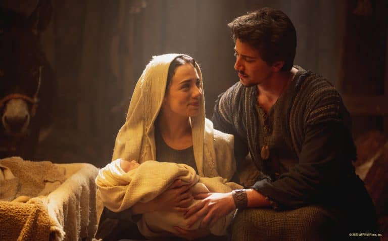 A man and woman holding a baby in a manger.