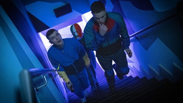A group of people walking down a stairway with blue lights.