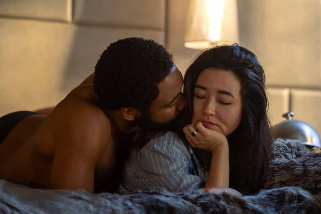 A man and a woman laying on a bed.